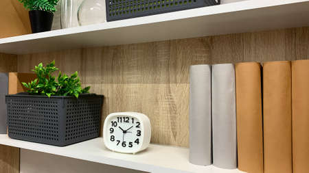 Decorative shelf in the living room with books, plants and decorations in a new apartment
