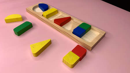 Wooden colorful game with geometric shapes for the development of children in kindergarten