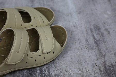 Beige women's leather flip flops for a summer walk on a white backgroundの写真素材