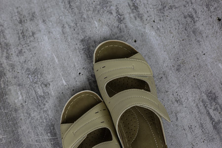 Beige women's leather flip flops for a summer walk on a white backgroundの写真素材