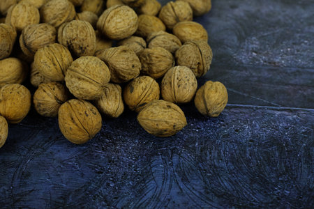 Peeled walnuts. Many closed nuts scattered on a blue backgroundの写真素材