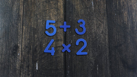 Task in mathematics. Mathematics problem for children. Simple algebra examples using numbers and signs from plastic numbers on a wooden background.の写真素材