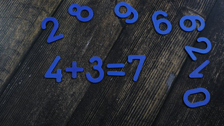 Task in mathematics. Mathematics problem for children. Simple algebra examples using numbers and signs from plastic numbers on a wooden background.の写真素材