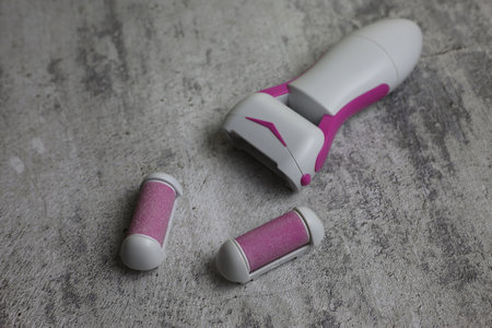 Electric callus remover. Sanding roller for removing rough skin from the feet. Pink grinding head on...