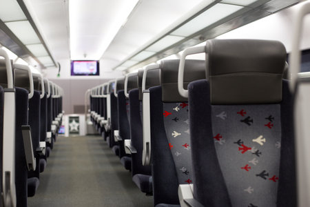 Train corridor with empty seats. Rows of seats in public transport without people, concept of traveling by railの写真素材