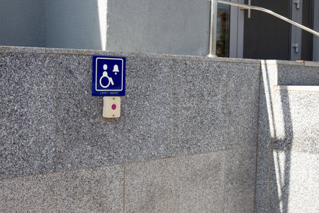 Access to building door for disabled people. Sign with braille text and symbol of person in...