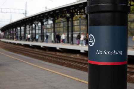 No smoking sign at stop of passenger trains, inscription on pole prohibiting smoking on the platform...