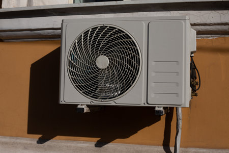 Photo of an air conditioner on wall of building, fan for taking air from the street and cooling house in hot weather, air conditioner on facadeの写真素材