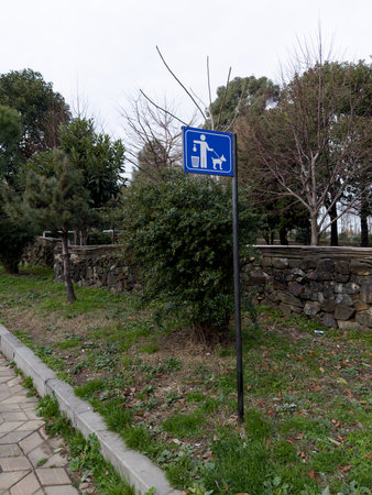 Sign on pole in park to remind you to clean up after your pets walking outside. Taking care of cleanliness of the city, cleaning up after pets in public places.の写真素材