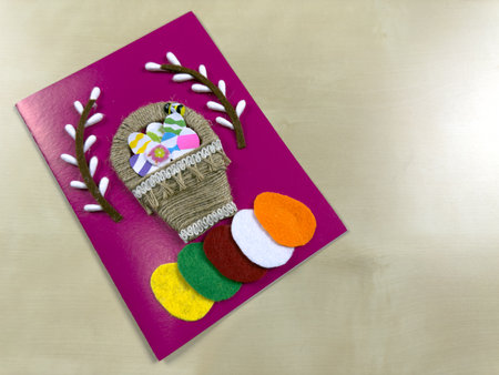 Delightful handmade Easter card features charming basket filled with colorful felt eggs and willow. Perfect for spreading joy and warm wishes during the Easter holiday seasonの写真素材