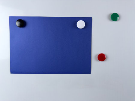 Blue note paper attached to whiteboard with colorful magnets perfect for reminders presentations and creative workspaces useful in both office and educational settingsの写真素材