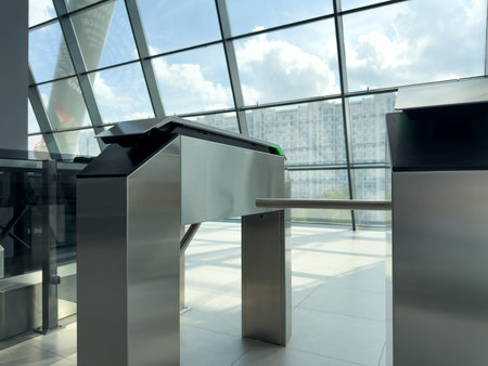 Modern turnstile at a glass-walled entrance, highlighting advanced design and technology. The steel...