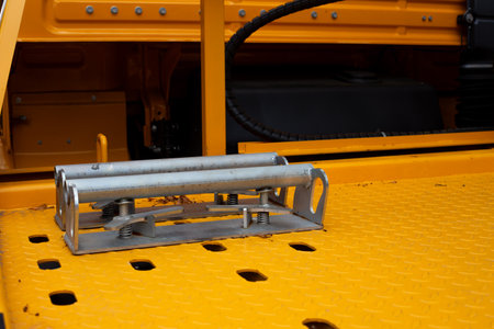 Close-up of wheel chocks on a yellow tow truck, designed to secure the wheels during vehicle...