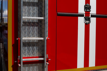 Rear of fire truck with ladder. Red vehicle with white stripes to indicate special emergency...