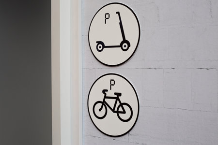 Parking signs for scooter and bicycle in urban environment. Clear and simple symbols indicating parking spots, ideal for city planning, urban transportation and sustainable mobility solutionsの写真素材