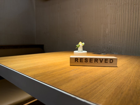 Reserved sign on restaurant table with soft lighting, minimalistic modern design. Cozy atmosphere for exclusive dining experiences or table reservations in upscale restaurantsの写真素材
