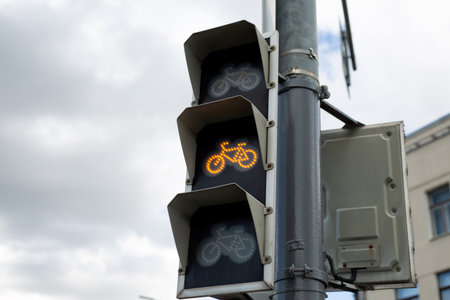 Yellow bicycle traffic light, indicating to slow down and prepare for stop. Highlighting the importance of safe cycling and traffic management in urban environmentsの写真素材