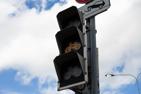 Bicycle traffic light showing transition phase with yellow light, indicating that cyclists should...