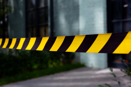 Close up of caution tape marking crime scene. The yellow and black stripes emphasize the restricted...