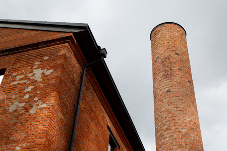 Close up view of old brick chimney and weathered brick wall, showcasing industrial architecture with...