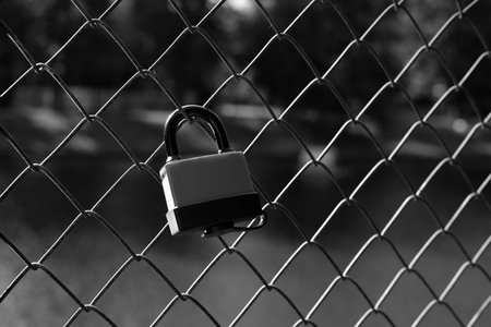 Black and white photo beautifully conveys a quiet yet powerful moment. Solitary lock on fence...