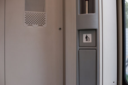 Train passengers interior showing trash bin for, featuring clear signage to encourage proper waste...