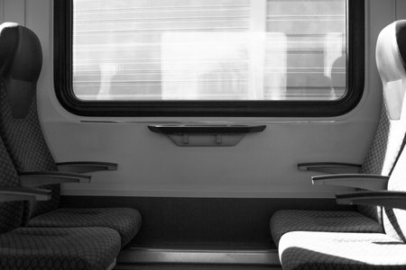 Solitary, empty seat inside train, evoking feelings of loneliness and isolation during journey. Symbolic image of traveling alone, far from friends and family, filled with solitude and melancholyの写真素材