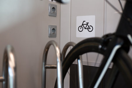 Close up image of bicycle placed in bike rack inside train, with bike symbol on wall indicating bike friendly facilities for passengers traveling with their bicyclesの写真素材