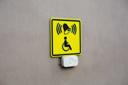 Plain wall with disabled sign and call button. News about creating accessible environment for people with disabilities. Concept for helping people. Take care of personsの写真素材