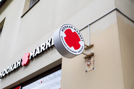 Moscow, Russia, November 16, 2025: Wall sign for hookah shop by Hookah Market. Chain of stores selling hookah accessories, tobacco, and coals. White and red logo of Hookah Marketのeditorial素材
