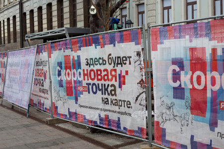 Moscow, Russia, November 16, 2025: There will soon be new bright spot on map here. Sign on fence surrounding construction site warns residents that new attraction will soon be builtのeditorial素材