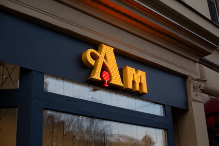 Moscow, Russia, November 16, 2025: Sign for Aromatny Mir store with illuminated letters Am and glass of wine. Aromatny Mir stores offer affordable alcoholic beverages and premium spirits in gift boxesのeditorial素材