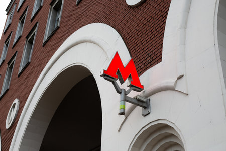 Moscow, Russia, November 16, 2025: Wall sign with the Moscow Metro logo. The illuminated red letter M at the entrance to the Moscow Metro lobby indicates the green and grey linesのeditorial素材