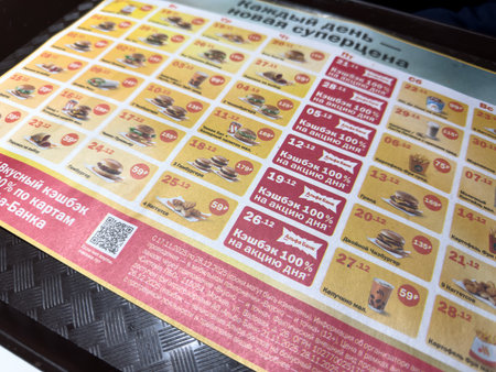 Moscow, Russia, November 21, 2025: Paper tray liner from fast food chain Vkusno i Tochka. Discount schedule in Vkusno i Tochka Delicious Calendar. Alfa Bank collaboration with food chainのeditorial素材