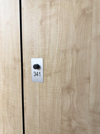 Close up vertical photo of locker door mechanism in gym. Secure storage with keyless access in public locker. Concept for secure storage of personal belongings in gym changing roomの写真素材