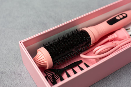 Ideal pink electric multi-styler for any hairstyle. Cylindrical brush with comb and clips on neutral...
