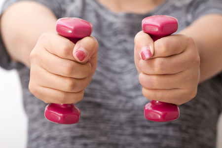 A female hand close-up with a dumb bellの写真素材