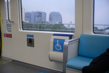 A designated seating area inside a public train marked for passengers with disabilities.の写真素材