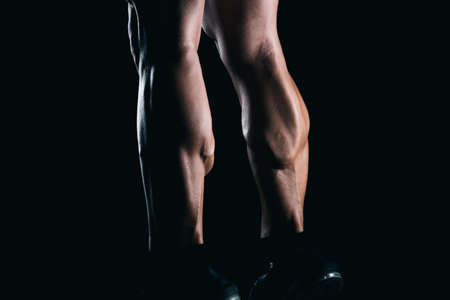 Strong man on tiptoe with black background.の写真素材