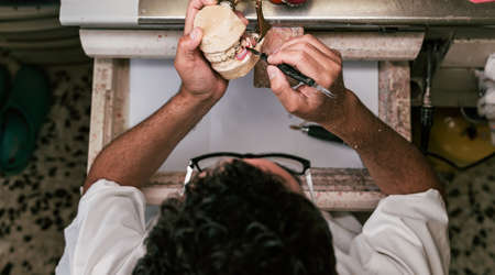 Dental technician fixing the parts of a dental prosthetic