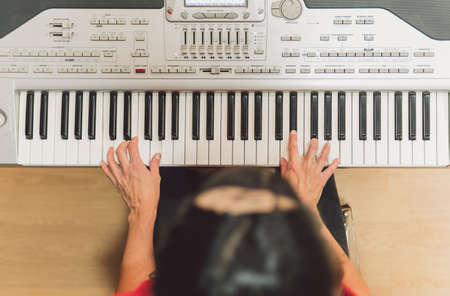 Aerial photo of a woman playing electronic piano