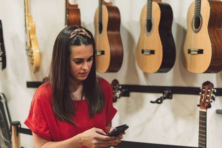 Woman using the mobile in a instruments store