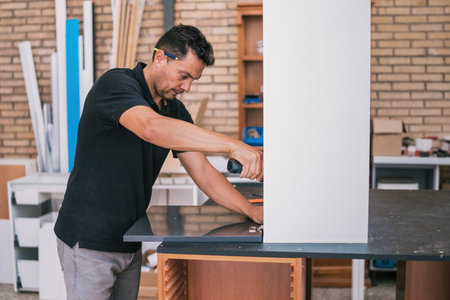 Man fixing a cabinet door with a drill.の写真素材
