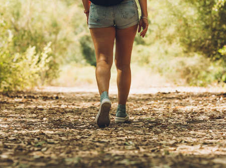 Legs of a woman in shorts walking across a the forestの写真素材