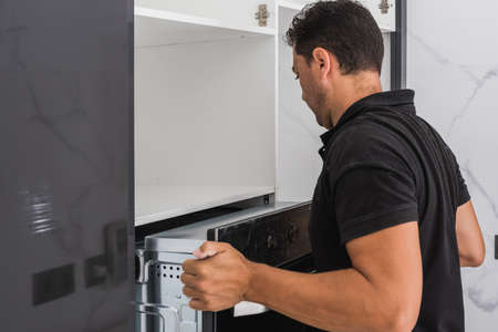 Man installing an oven in a new kitchen