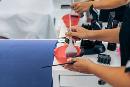 Close up view of a hairdresser preparing a dye mixture in a salonの写真素材