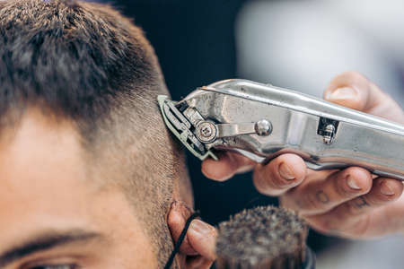Close up view of a machine shaving the hair of a customer in a barbershopの写真素材