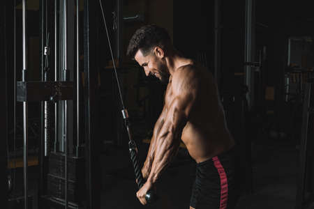 Strong man pulling from a weigh machine in a gymの写真素材