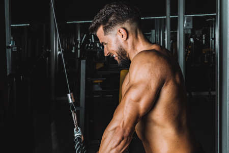 Strong man exercising with a weigh machine in a gymの写真素材