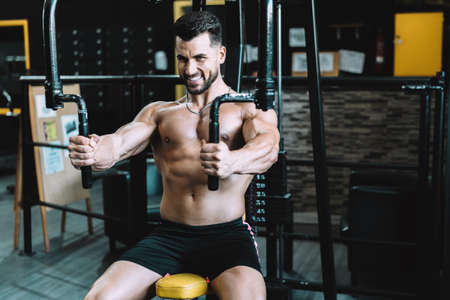Portrait of a man exercising with weights using a machine in a gymの写真素材